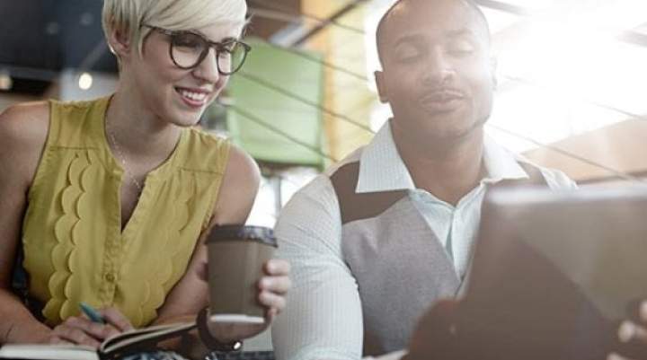 Woman and man analyse Partnerize attribution data on screen