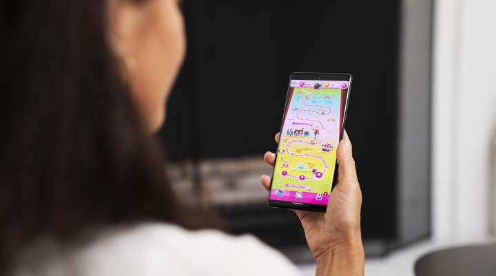 A woman plays Candy Crush Saga on her phone