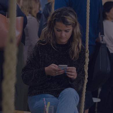 woman looking on her phone and sitting on a swing