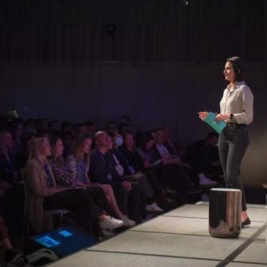 Woman on stage speaking to a crowd