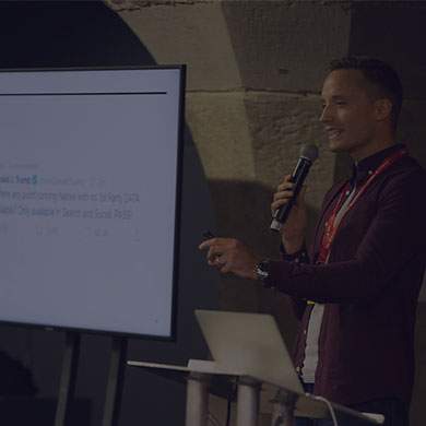 Stock photo of man speaking in front of a slide show