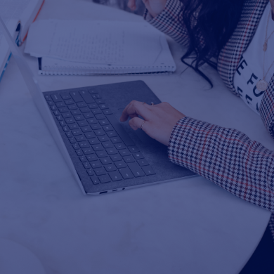 Woman using laptop and writing notes