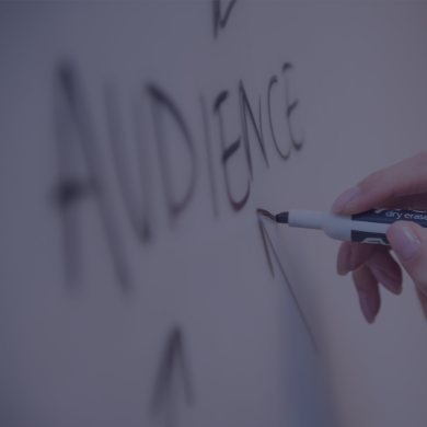 Person writing the word audience on a whiteboard