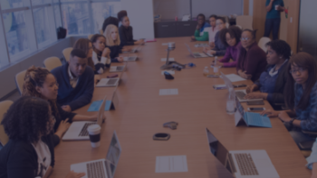 A diverse panel of speakers sat around a conference table