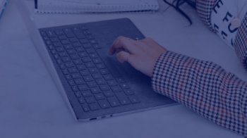 Woman using laptop and writing notes