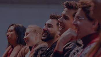 Stock image of people sitting in a line and laughing