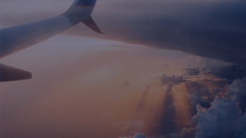Tail end of aeroplane flying across ocean