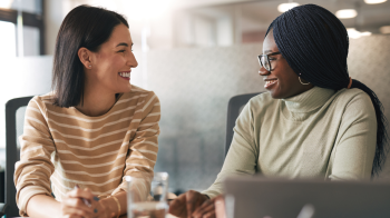 Two women smiling at each other 
