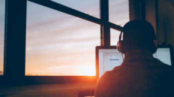 Someone using a computer during a sunset