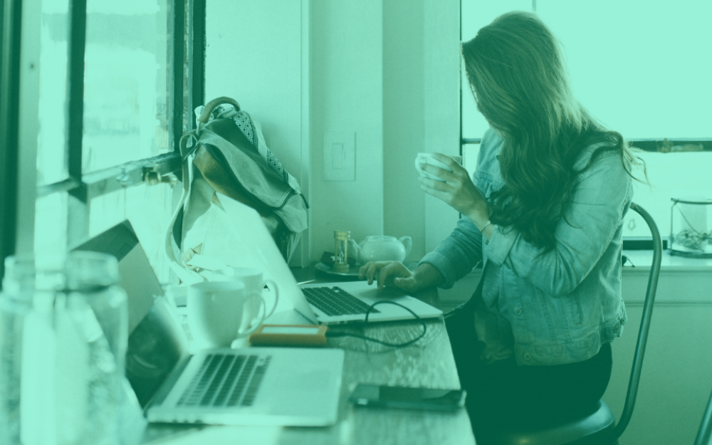 Woman using laptop and drinking coffee